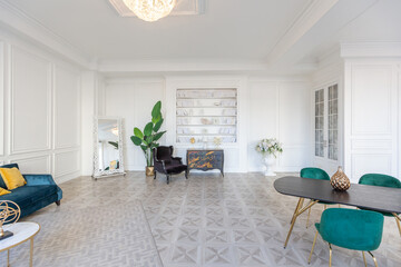 modern and very stylish interior design of large studio apartment with fashionable furniture with gold elements. very light and bright room with big windows