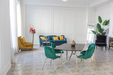 modern and very stylish interior design of large studio apartment with fashionable furniture with gold elements. very light and bright room with big windows