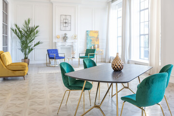 modern and very stylish interior design of large studio apartment with fashionable furniture with gold elements. very light and bright room with big windows