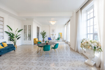 modern and very stylish interior design of large studio apartment with fashionable furniture with gold elements. very light and bright room with big windows