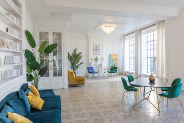 modern and very stylish interior design of large studio apartment with fashionable furniture with gold elements. very light and bright room with big windows
