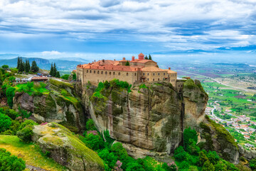 Fototapeta na wymiar Temple Meteora Greece. Spectacular summer panoramic landscape of UNESCO heritage list object. Scenic view at the orthodox monastery at the summit of steep rock in Greece.