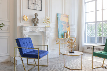 modern and very stylish interior design of large studio apartment with fashionable furniture with gold elements. very light and bright room with big windows