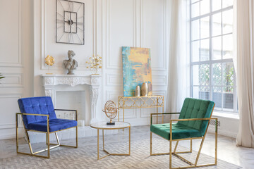 modern and very stylish interior design of large studio apartment with fashionable furniture with gold elements. very light and bright room with big windows