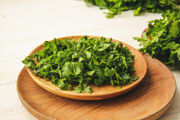 Plate with fresh parsley on table