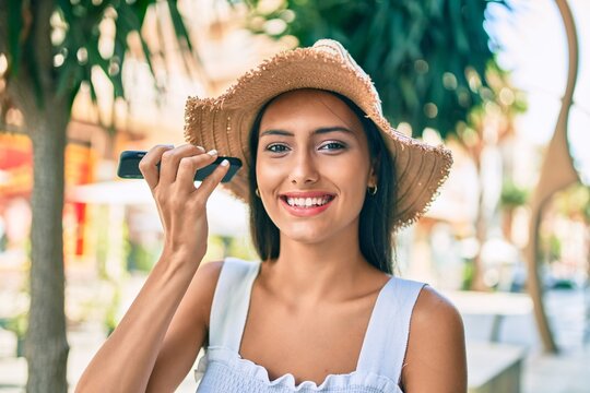 Young latin girl wearing summer style talking on the smartphone at street of city.