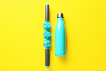 Body roller with bottle of water on color background