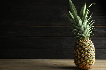 Fresh ripe juicy pineapple on wooden table. Space for text