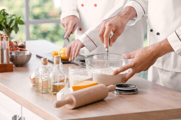 Obraz na płótnie Canvas Chefs cooking tasty dish in kitchen