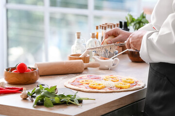 Obraz na płótnie Canvas Chef making tasty pizza in kitchen