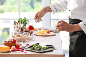 Mature chef cooking in kitchen, closeup
