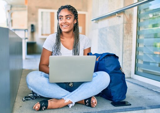Young african american student woman smiling happy using computer laptop at the university campus