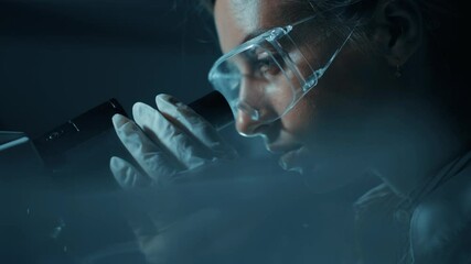 Female scientist is looking through a microscope in laboratory and using microscope for bacterial contamination of water to search for vaccine to treat diseases in medicine. - Powered by Adobe