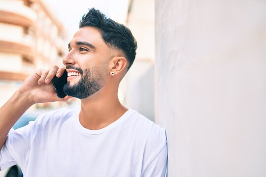 Young arab man with serious expression talking on the smartphone at the city.