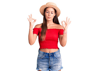 Obraz na płótnie Canvas Young beautiful hispanic woman wearing summer hat relax and smiling with eyes closed doing meditation gesture with fingers. yoga concept.