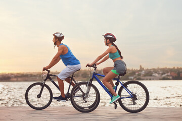Fototapeta premium Sporty young cyclists riding bicycles near river