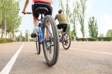 Sporty cyclists riding bicycles outdoors