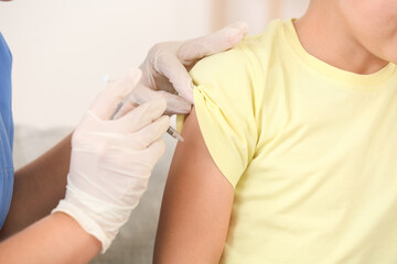 Doctor giving diabetic boy insulin injection at home