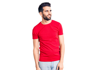 Obraz premium Young handsome man with beard wearing casual t-shirt looking away to side with smile on face, natural expression. laughing confident.