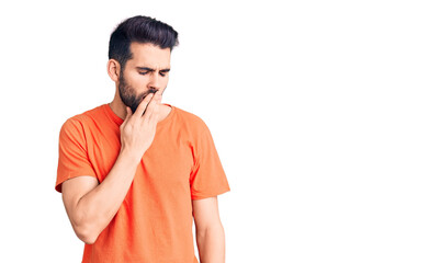 Young handsome man with beard wearing casual t-shirt bored yawning tired covering mouth with hand. restless and sleepiness.