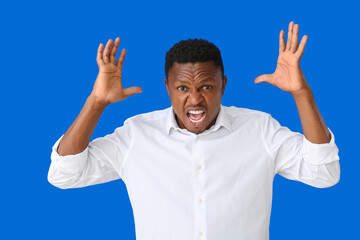 Stressed African-American man on color background