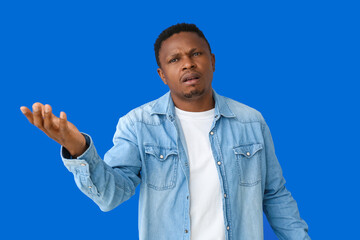 Stressed African-American man on color background