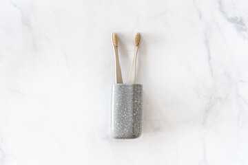 Fototapeta na wymiar Composition with biodegradable bamboo toothbrushes on marble background. Sustainable, zero waste, plastic free, lifestyle concept. Eco-friendly oral hygiene accessories. Flat lay, top view, copy space