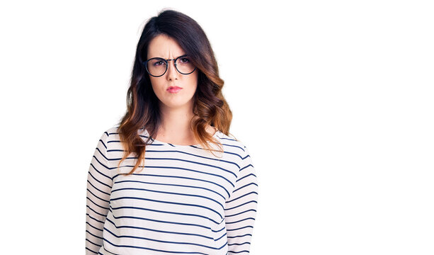 Beautiful young brunette woman wearing casual clothes and glasses skeptic and nervous, frowning upset because of problem. negative person.