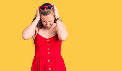 Young beautiful blonde woman wearing casual dress suffering from headache desperate and stressed because pain and migraine. hands on head.
