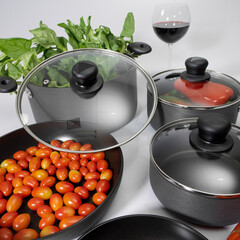 kitchenware - Set of non-stick pots with glass lids; photo on white background.
