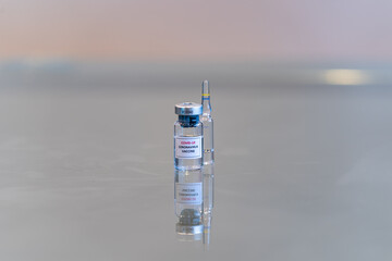A vial containing a COVID-19 coronavirus vaccination drug with an ampule in the rear with copy space - 056