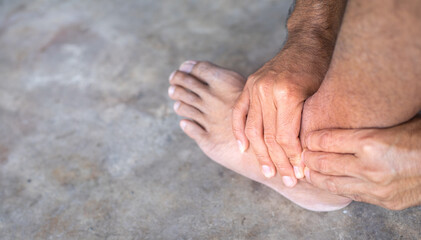 man with ankle pain holding her aching leg, body pain concept