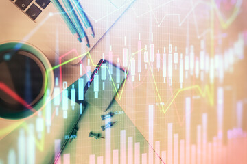 Double exposure of forex graph drawing over desktop background with computer. Concept of financial analysis. Top view.