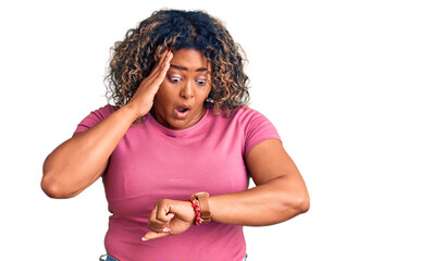 Young african american plus size woman wearing casual clothes looking at the watch time worried,...