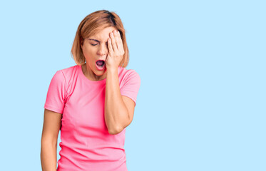 Fototapeta premium Young blonde woman wearing sportswear yawning tired covering half face, eye and mouth with hand. face hurts in pain.