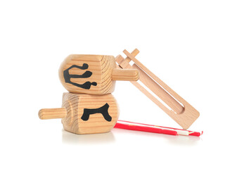 Dreidels for Hanukkah with rattle and candles on white background