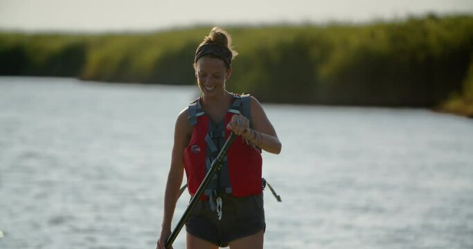 Smiling girl on paddleboard on a summer day in the sound