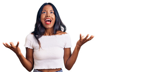 Young indian girl wearing casual clothes crazy and mad shouting and yelling with aggressive...