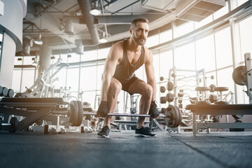 Training in gym, Handsome man with a mustache, do muscle building exercises using dumbbells, focusing on lifting and sit-ups in a fitness sport.