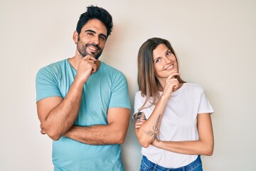 Beautiful young couple of boyfriend and girlfriend together looking confident at the camera smiling with crossed arms and hand raised on chin. thinking positive.