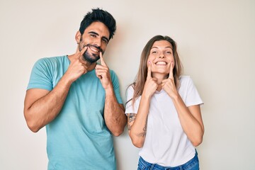 Beautiful young couple of boyfriend and girlfriend together smiling with open mouth, fingers pointing and forcing cheerful smile