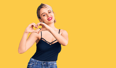 Young beautiful blonde woman wearing casual clothes smiling in love showing heart symbol and shape with hands. romantic concept.