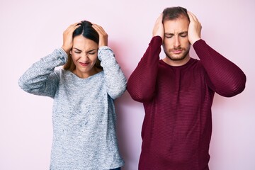 Beautiful couple wearing casual clothes suffering from headache desperate and stressed because pain and migraine. hands on head.
