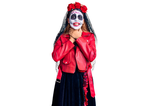 Woman wearing day of the dead costume over background shouting and suffocate because painful strangle. health problem. asphyxiate and suicide concept.