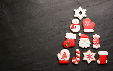 Fototapeta na wymiar Christmas tree shape made of delicious gingerbread cookies on black table, flat lay. Space for text