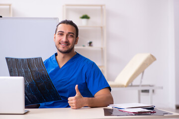 Young male doctor teacher radiologist in front of whiteboard