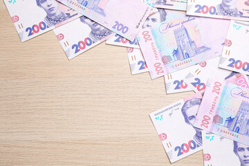 Ukrainian money on wooden background, flat lay. Space for text