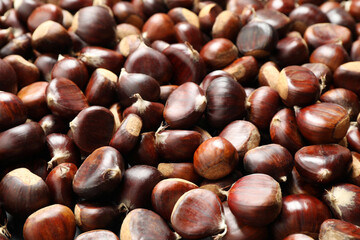 Fresh edible sweet chestnuts as background, closeup