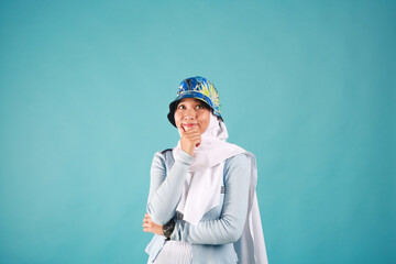 Fashion portrait of young beautiful asian muslim woman with wearing hijab on blue background. 