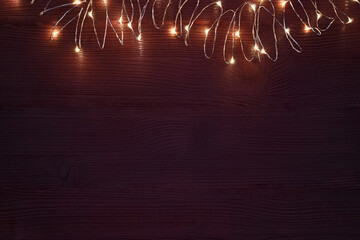 christmas garland string with warm lights on dark brown background